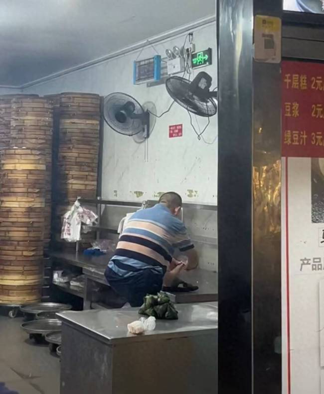 清泉阁包子铺店员踩操作台修脚